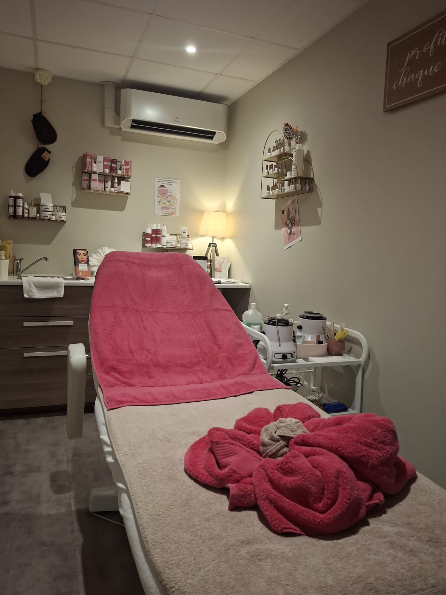 Cabine de soin de l'institut Esthétiquement Vôtre à Monnaie, table de soin et linge rose