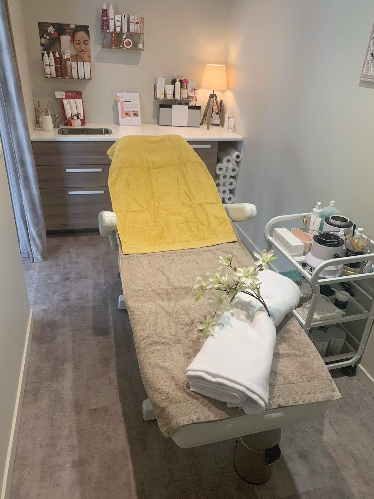 Cabine de soin de l'institut, table de massage avec serviettes et chariot de produits